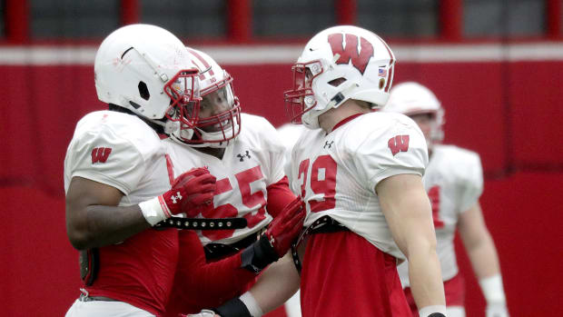Wisconsin inside linebackers Jordan Turner (54), Maema Njongmeta (55), and Tate Grass (39) talk during spring practice. (Credit: Mike De Sisti / Milwaukee Journal Sentinel / USA TODAY NETWORK)